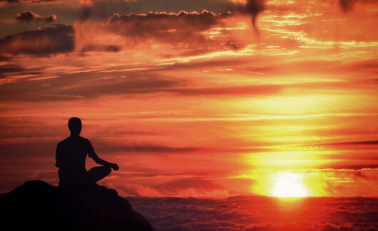 Meditation - Mindfulness - Person Meditating at Sunset Over the