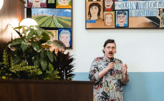 Klaas Rommelaere, een Belgische textielkunstenaar, tijdens een lezing